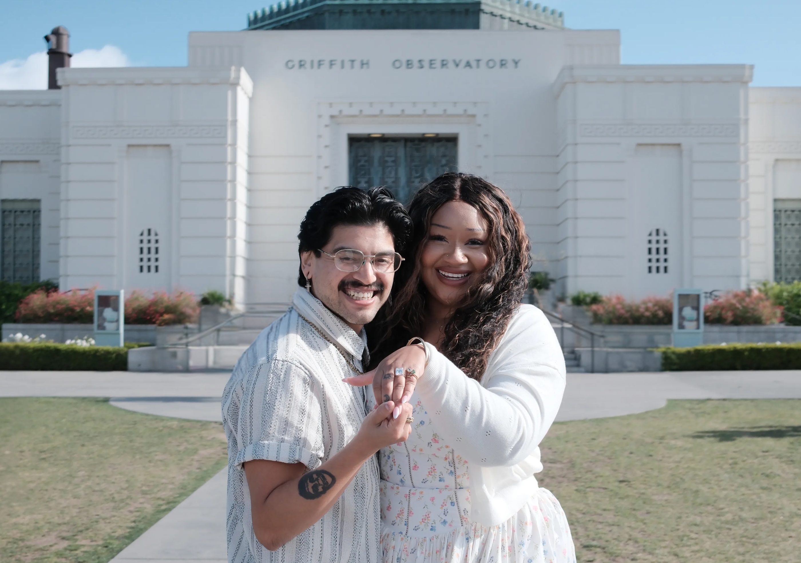 Two people dancing together in front of the Griffith Observatory.
